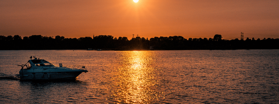Boot vaart over het water met de zonsondergang