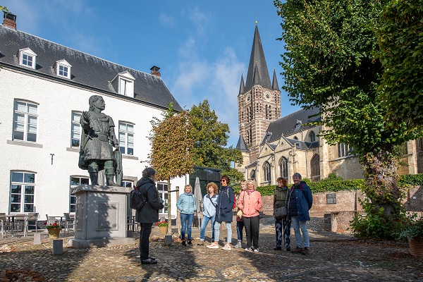 Group of visitors get a guided tour of Thorn with the Abbey Church in the background