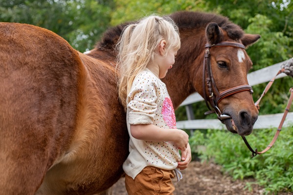 Mädchen steht neben ihrem Pony